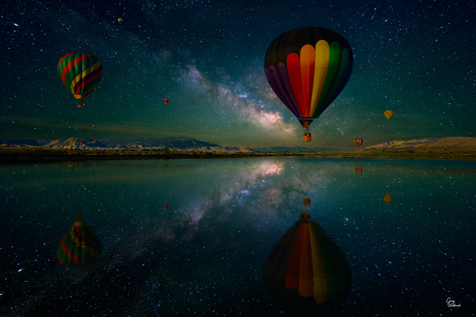 Colorful hot air balloon rising above a reflective lake under a star-filled Milky Way sky