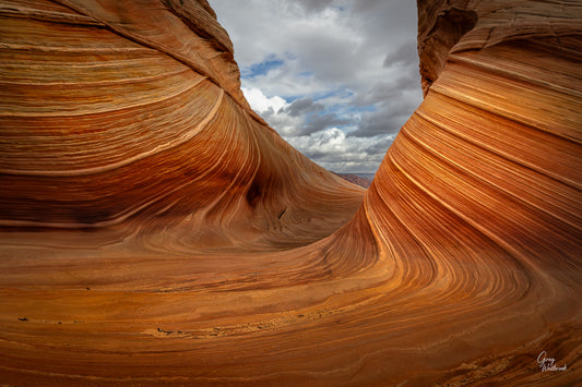 Sandstone formation with layered patterns under a cloudy sky fine art photography print by Greg Westbrook