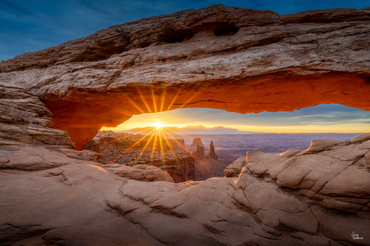 Sunstar glowing beneath Mesa Arch as dawn illuminates the Canyonlands landscape fine art photography print by Greg Westbrook